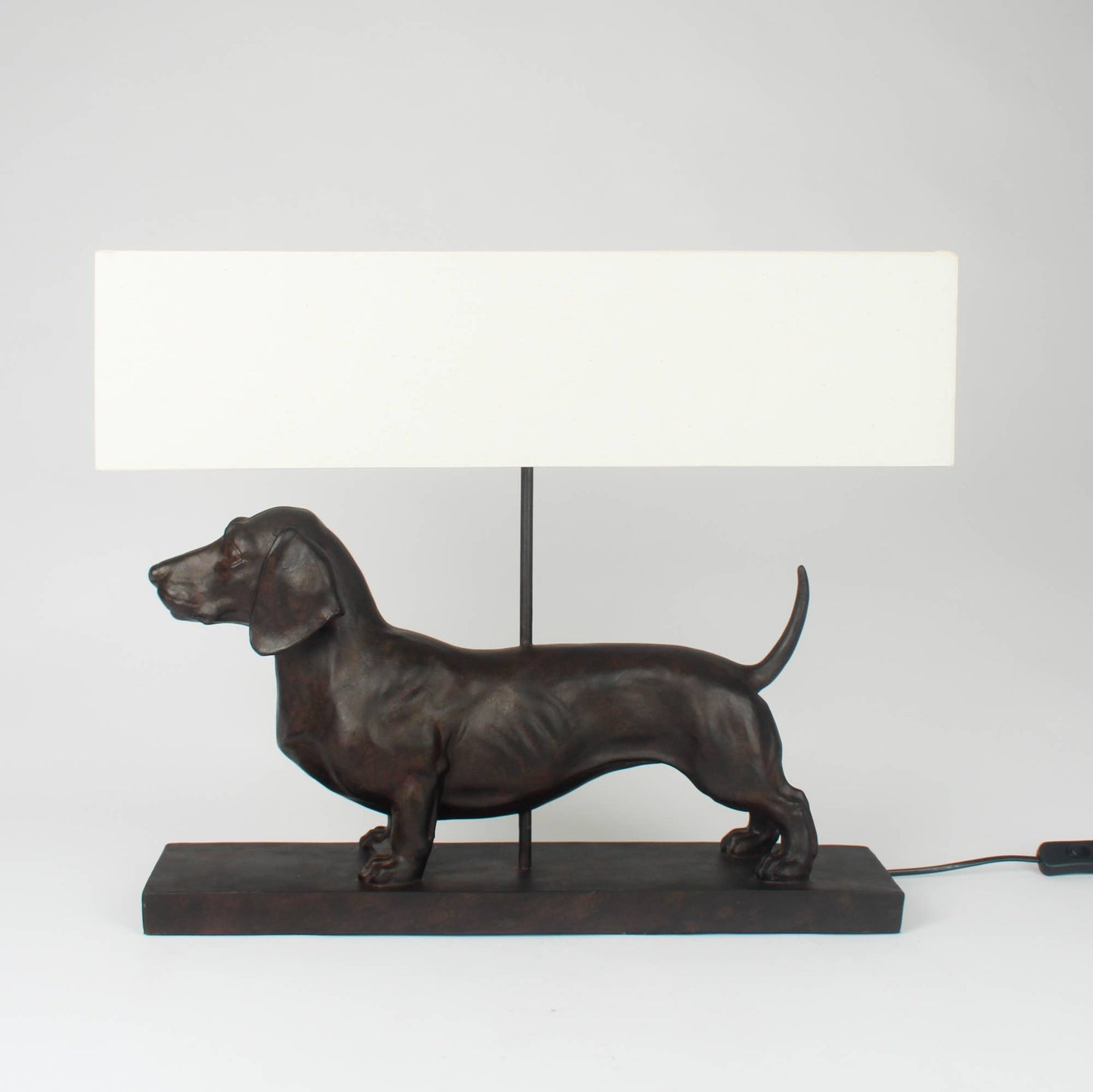 Dog-shaped table lamp with a white rectangular shade on a light gray background
